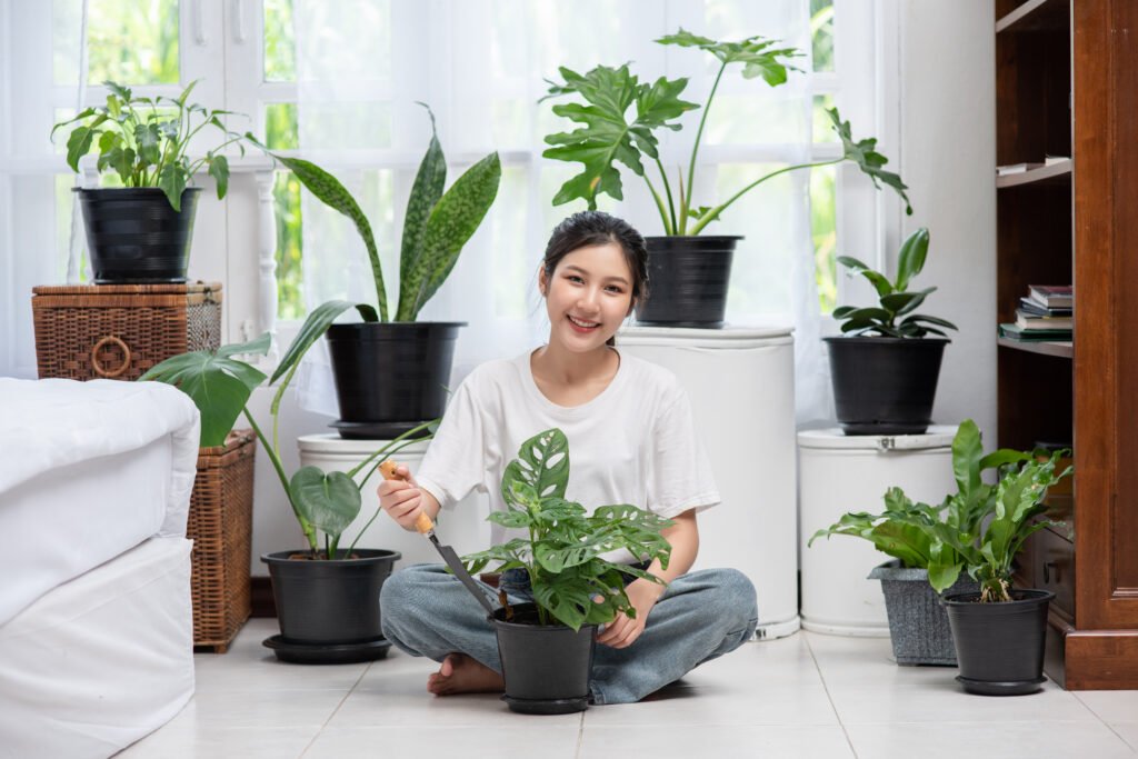 The woman is sitting and planting trees in the house